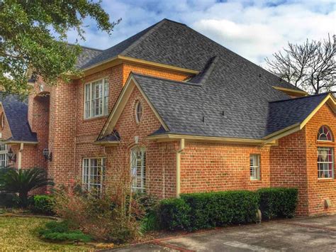 brick house with black metal roof|black shingles on brick house.